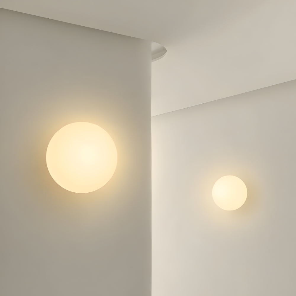 Round glass wall light with warm glowing globe