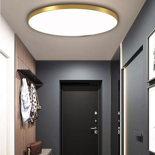 Gold-toned round flat LED ceiling light with white acrylic diffuser panel