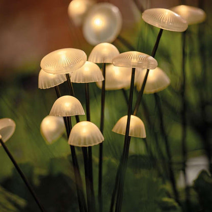 Solar mushroom garden lights with softly glowing caps on black poles