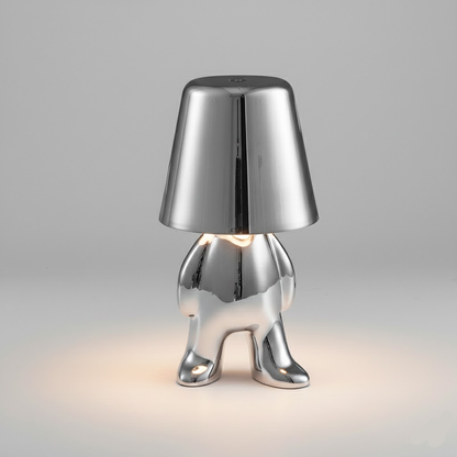 Silver metallic figure table lamp with bell shade and glowing bulb base