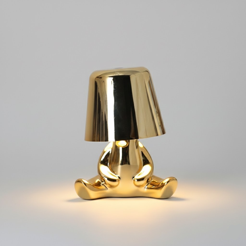 Gold figure table lamp with reflective dome shade and standing metallic base