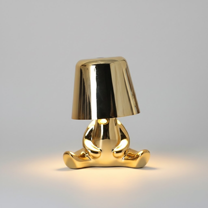 Gold figure table lamp with reflective dome shade and standing metallic base