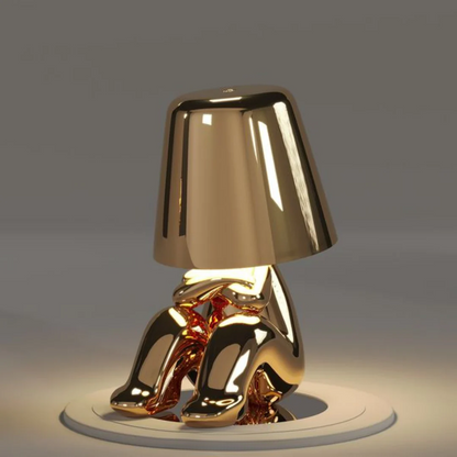 Gold modern figurine table lamp standing on a round base with conical shade, LED glow
