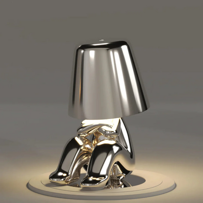 Gold LED figurine table lamp with sculpted base and metallic cone shade