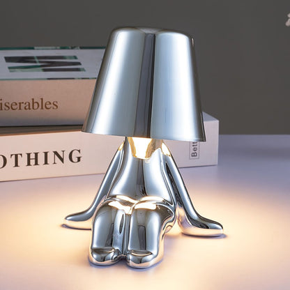 Silver figure table lamp, chrome-like finish, bell shade lit from the center