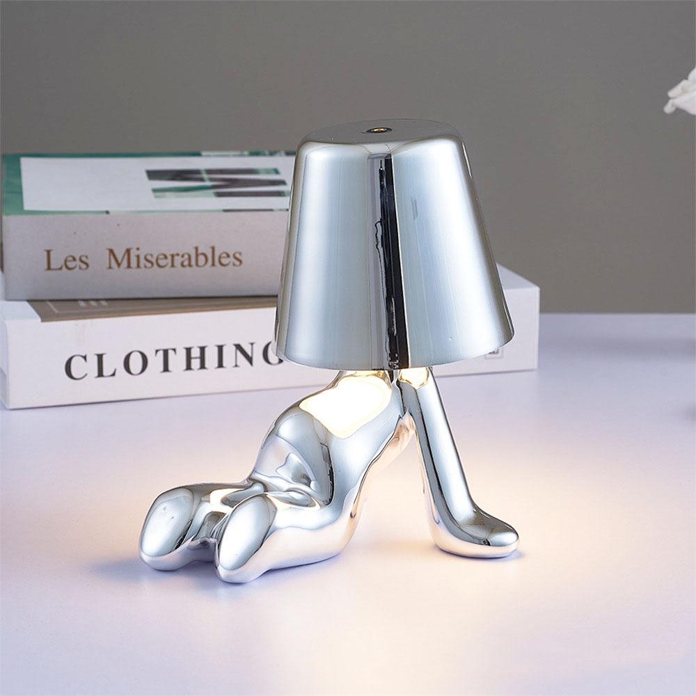 Silver figure table lamp with bell shade and reflective chrome-like body