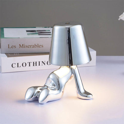 Silver figure table lamp with bell shade and reflective chrome-like body