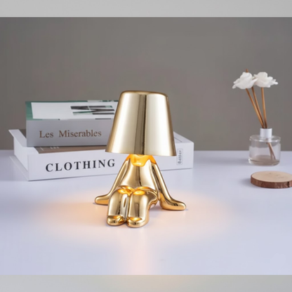 Gold figure table lamp on base with dome shade and reflective gold limbs