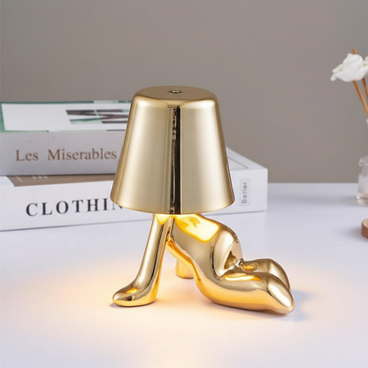 Gold figure table lamp with dome shade and seated reflective metallic form