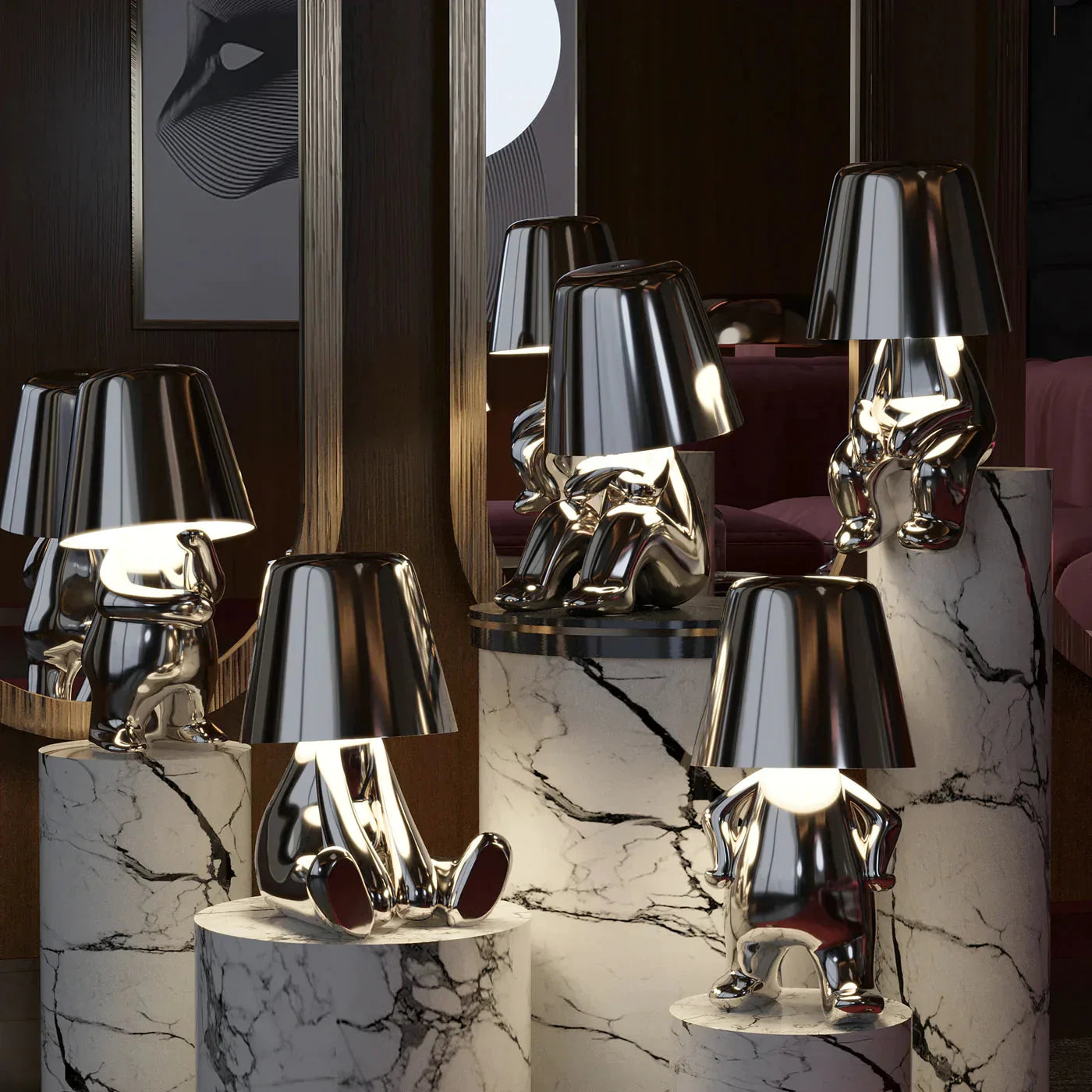 Group of silver LED figurine table lamps with metallic cone shades on marble shelf