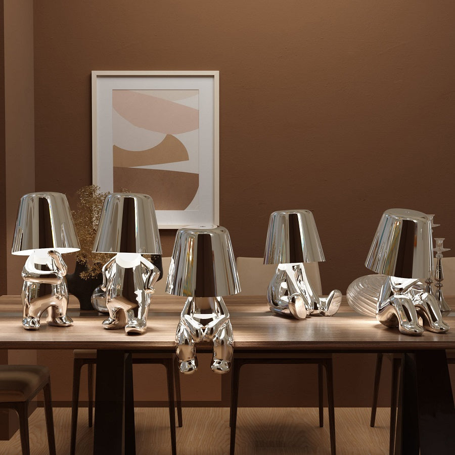 Set of gold LED figurine table lamps with metallic cone shades on console