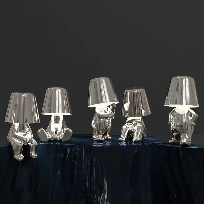 Silver LED figurine table lamps with metallic cone shades on dark table surface