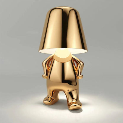 Gold figure table lamp with dome shade and standing chrome-like sculpted body