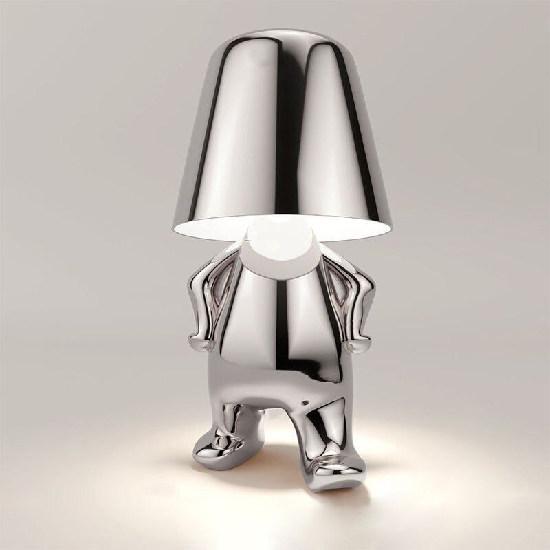 Silver figure table lamp with bell shade, reflective legs and glowing interior light