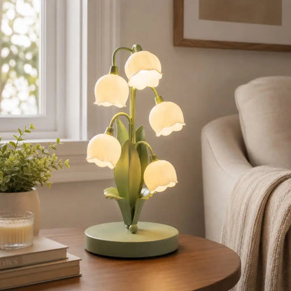 Floral table lamp with green base and five frosted bell shades on curved stems