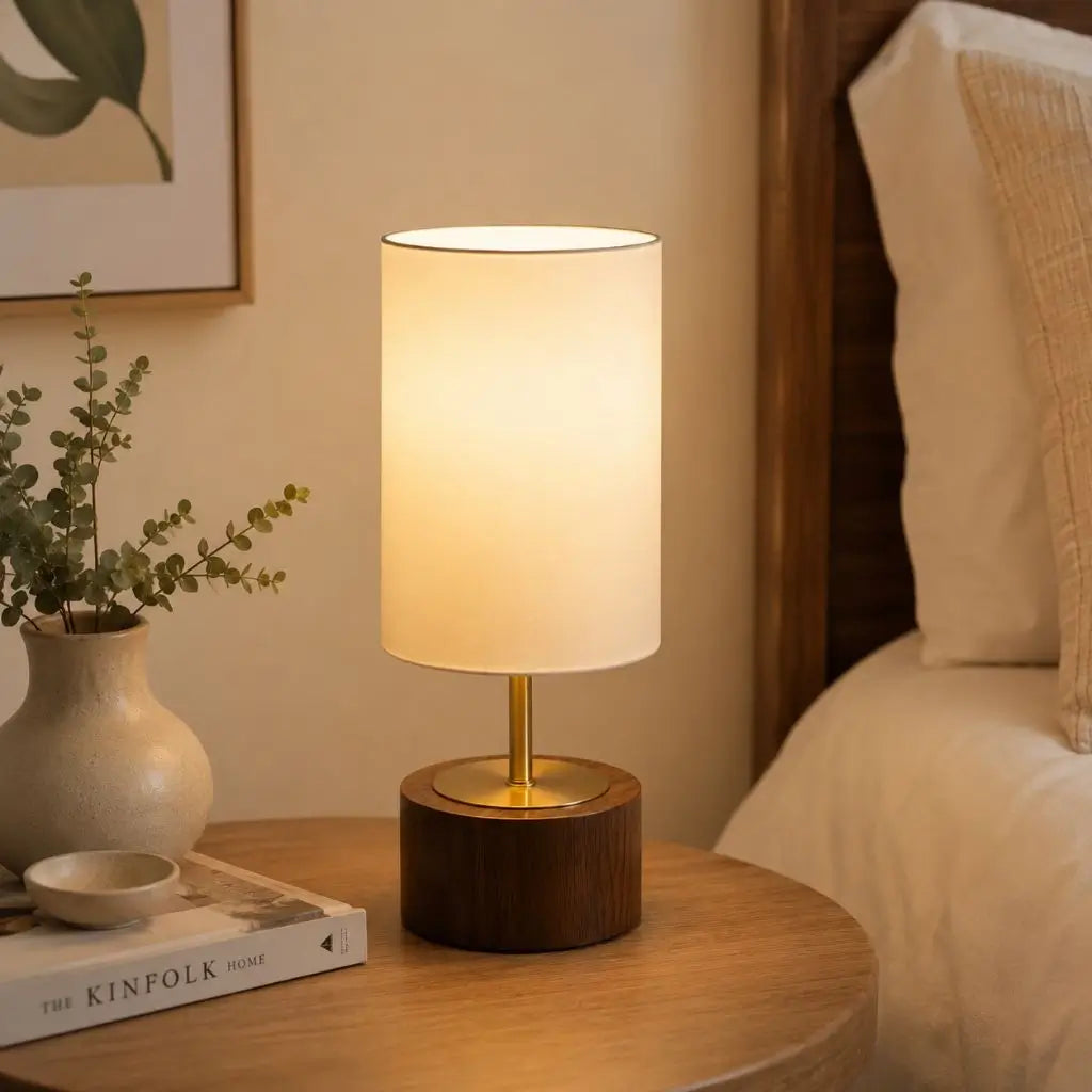 Small table lamp with white fabric shade and faux wood base with brass stem