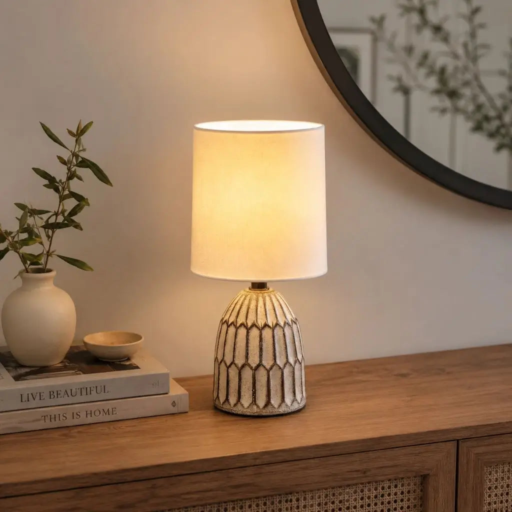 Small ceramic table lamp with white fabric drum shade and geometric base