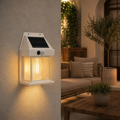 Solar-powered LED wall light, white housing, black solar panel, clear glass lantern