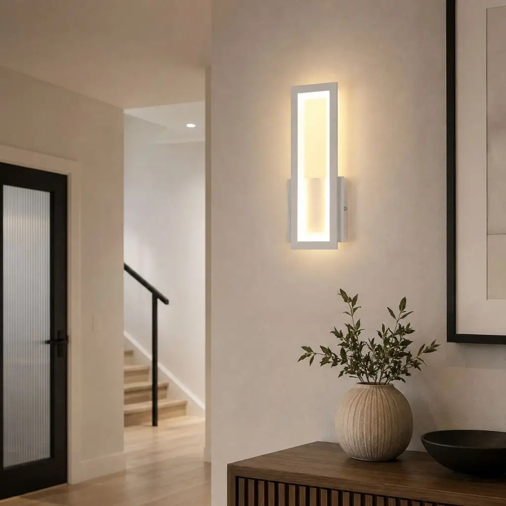 Wall-mounted LED light with white frame and warm-lit acrylic panel in hallway