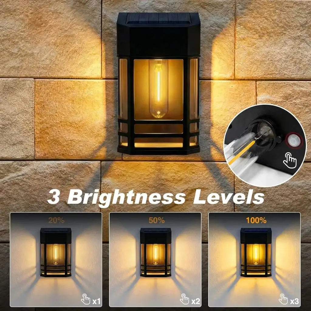 Solar wall lantern light, black frame with warm white lit bulb inside clear glass