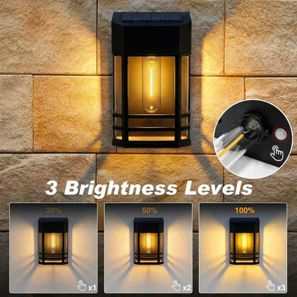 Solar wall lantern light, black frame with warm white lit bulb inside clear glass