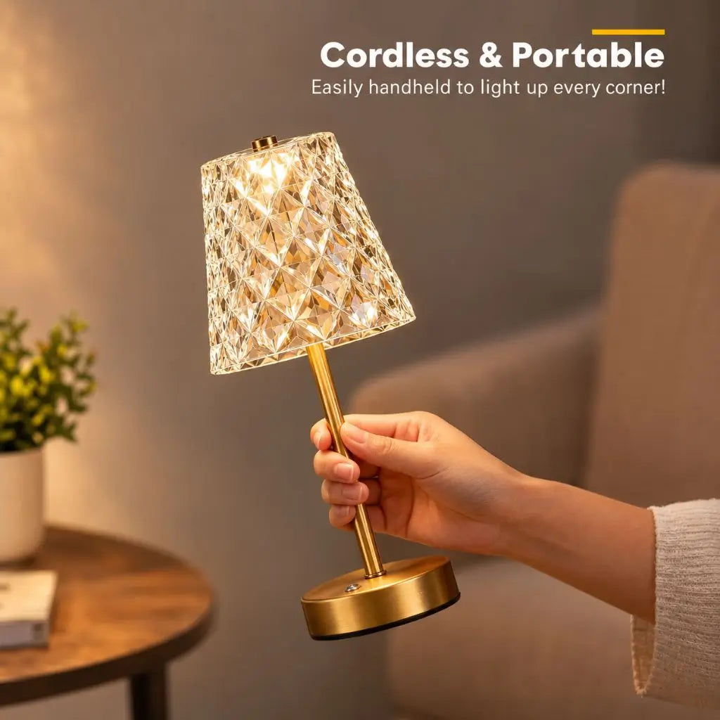 Cordless rechargeable table lamp held in hand, faceted shade with gold base