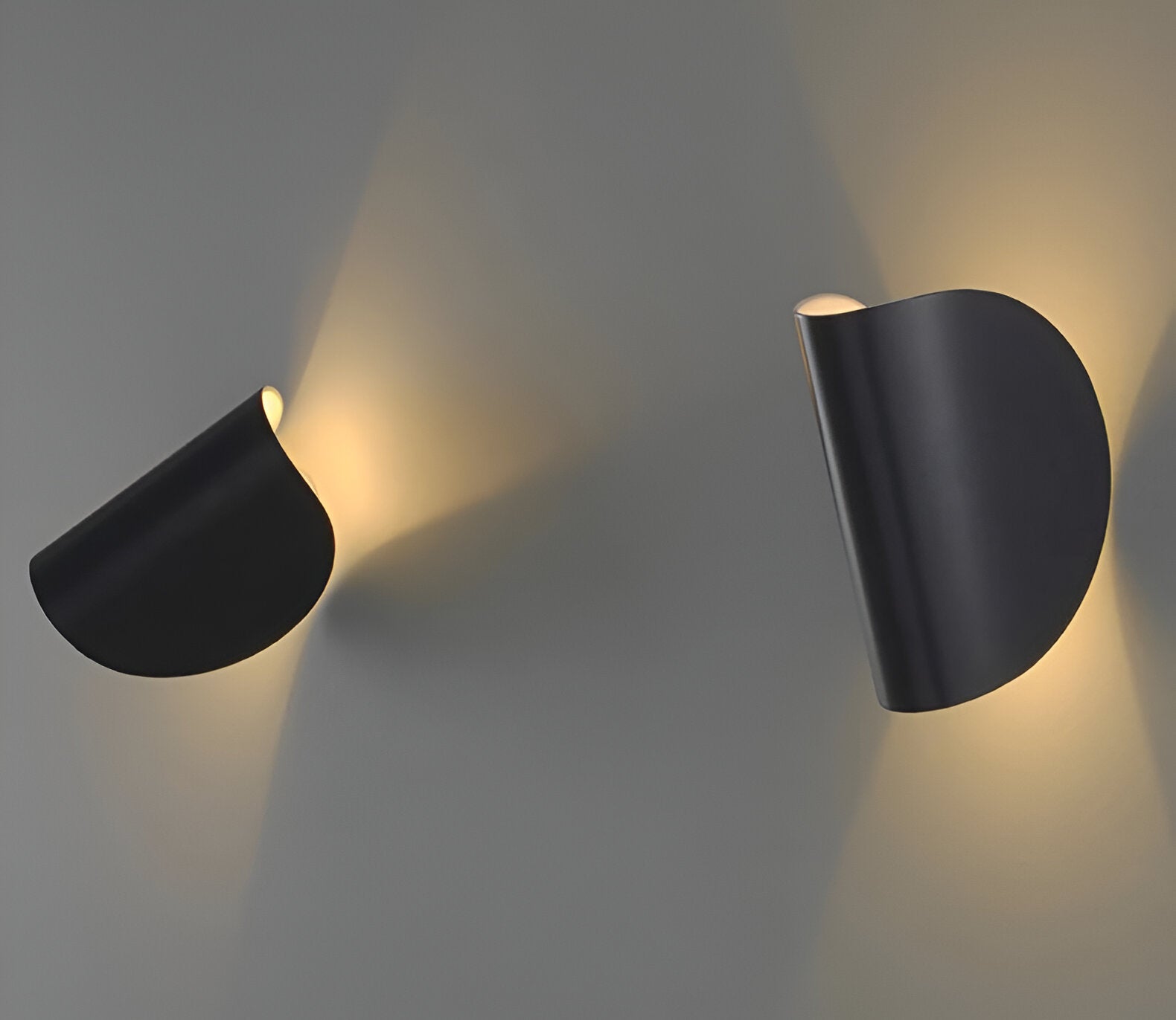 Adjustable metal wall light with matte black cone shades, mounted and rotated for light.