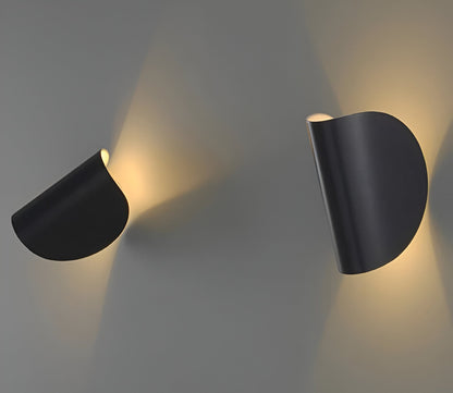 Adjustable metal wall light with matte black cone shades, mounted and rotated for light.