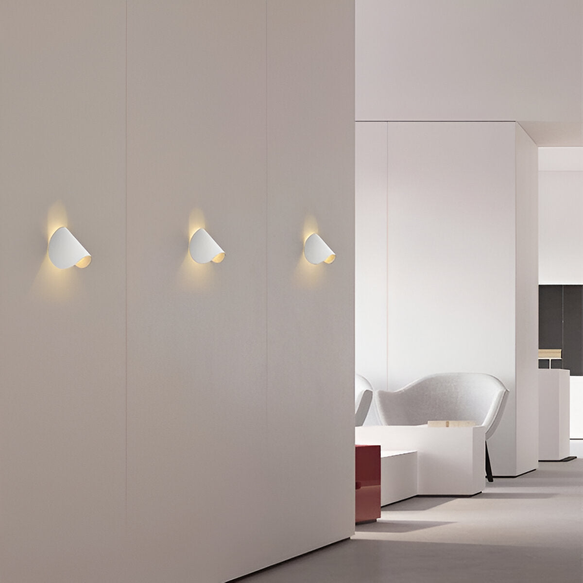White adjustable cone wall lights, three flush mounts on a smooth wall