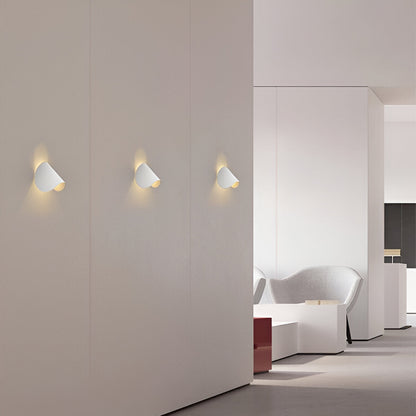 White adjustable cone wall lights, three flush mounts on a smooth wall