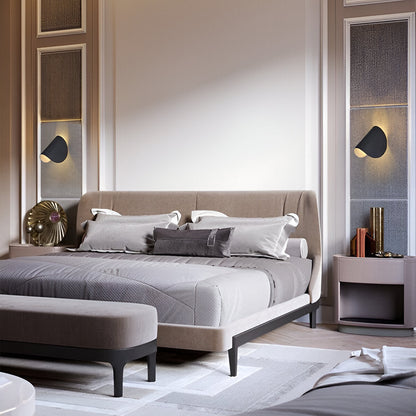 Adjustable metal wall light with black cone shade, mounted beside a window.