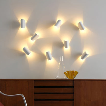 Cluster of adjustable metal wall lights with white shades, each angled to direct glow.