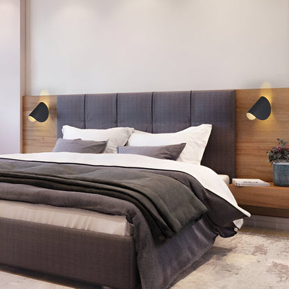 Adjustable metal wall light with black cone shade, mounted on a wood-paneled headboard wall.