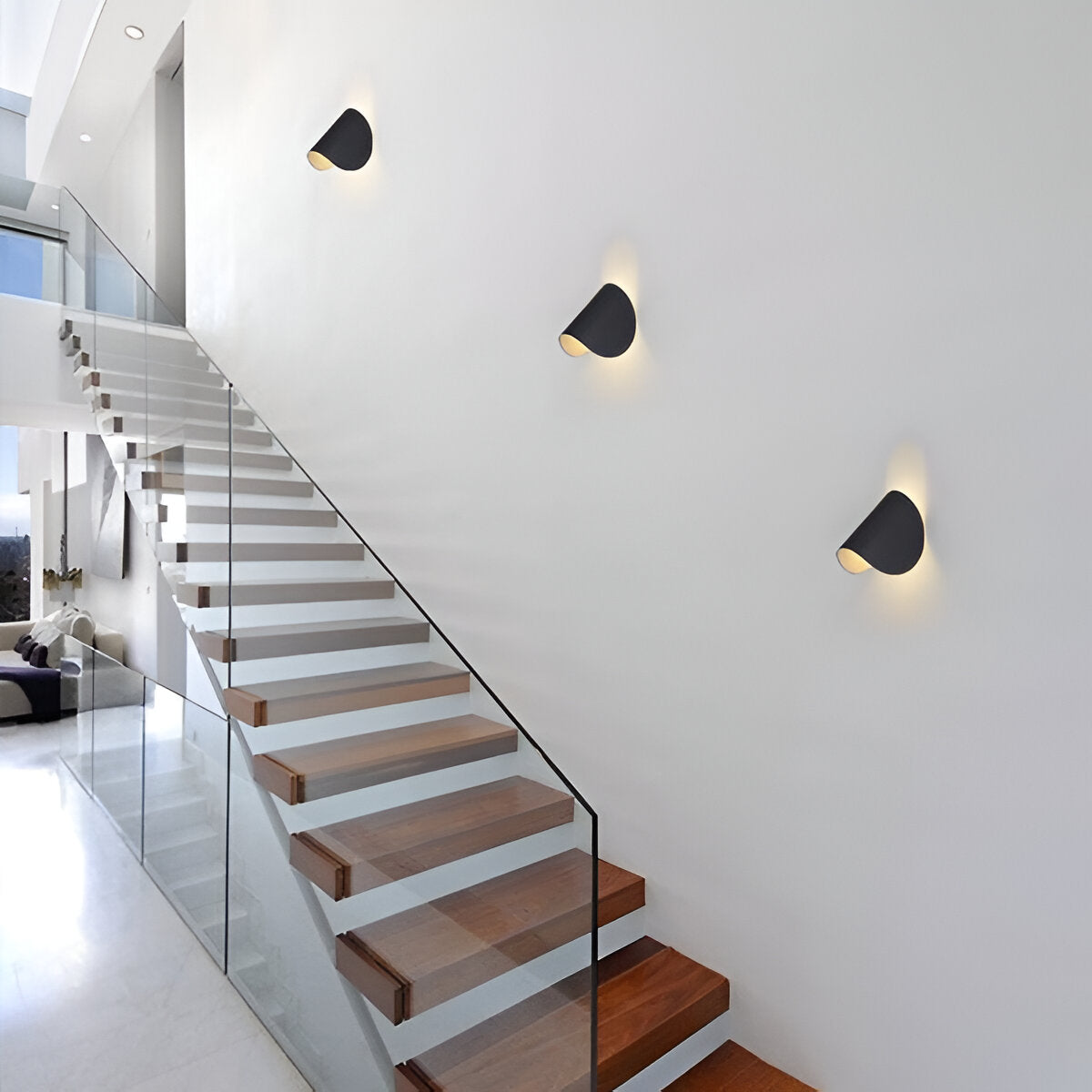 Black adjustable wall light with angled cone shade, multiple fixtures on wall
