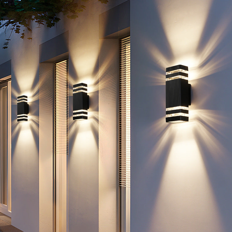 Modern outdoor wall light with aluminum trim and dark glass, stacked bands, glowing