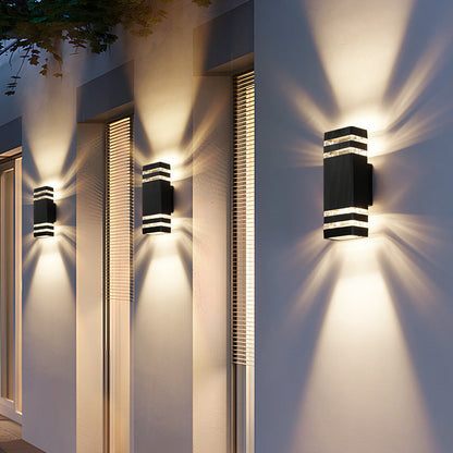 Modern outdoor wall light with aluminum trim and dark glass, stacked bands, glowing