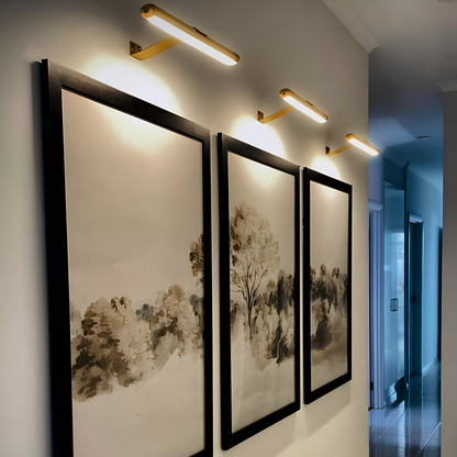 Gold LED picture wall sconces with slim bar housings and side wall brackets.