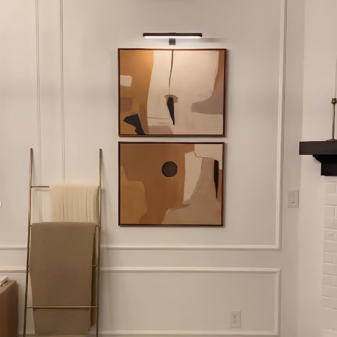 Cordless LED picture wall lamp with slim bar, mounted above two framed artworks