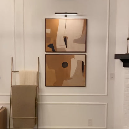 Cordless LED picture wall lamp with slim bar, mounted above two framed artworks