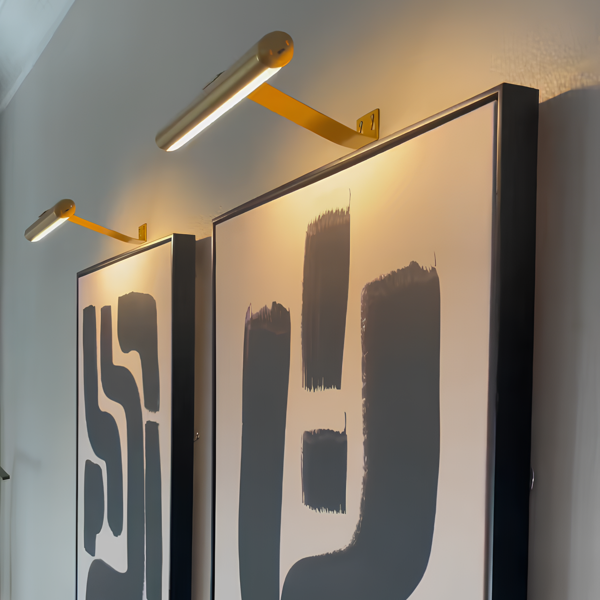 Cordless LED picture light, slim bars with gold mounts on dark backplates