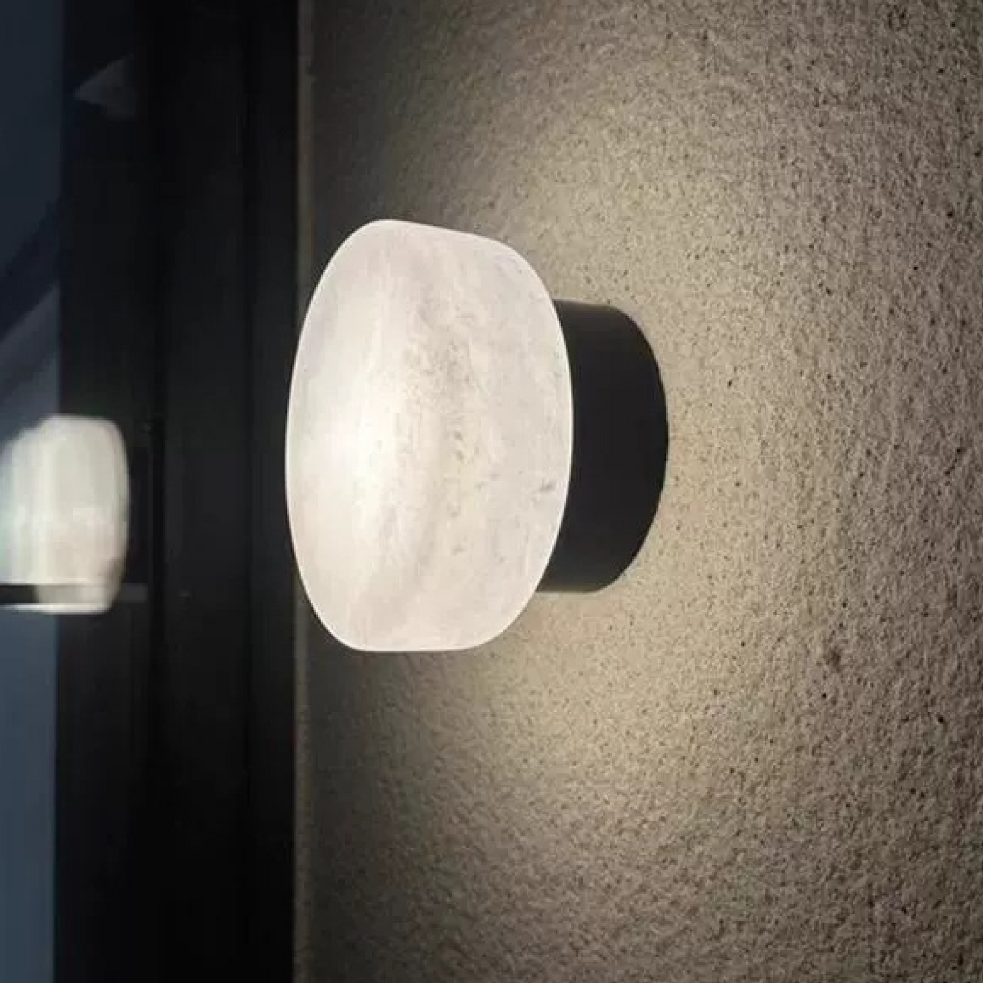 Marble-effect LED wall light with oval frosted diffuser and black backplate