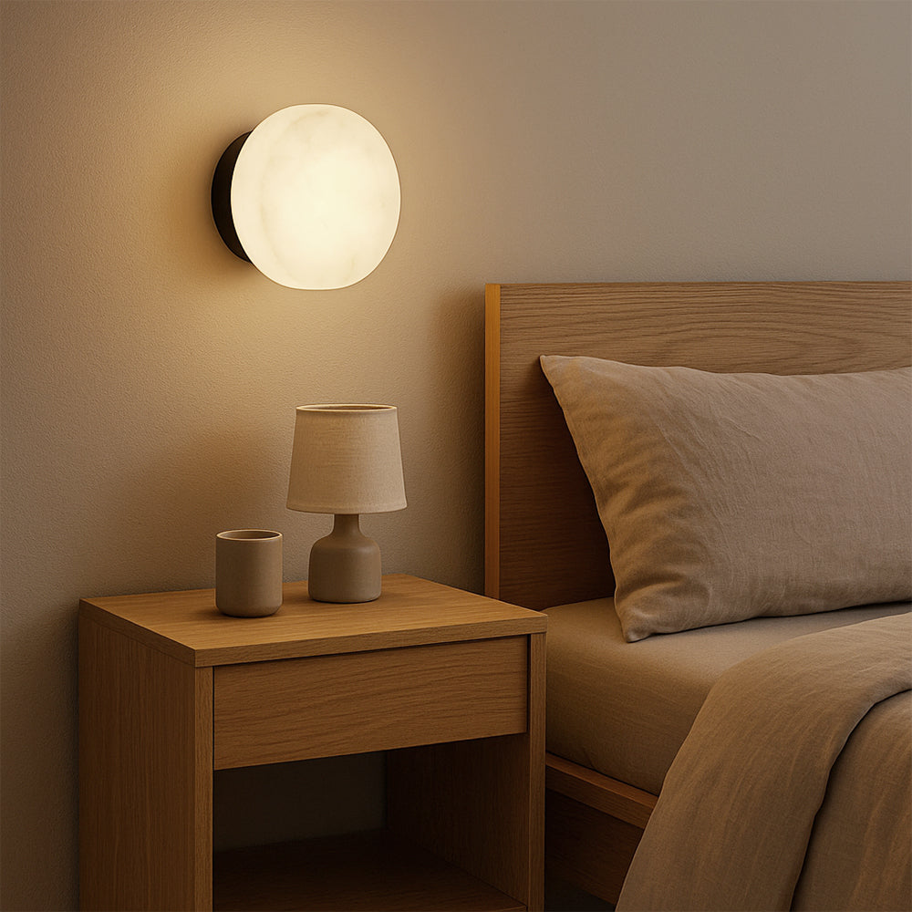 Black LED wall sconce with round marble-effect diffuser and warm light glow