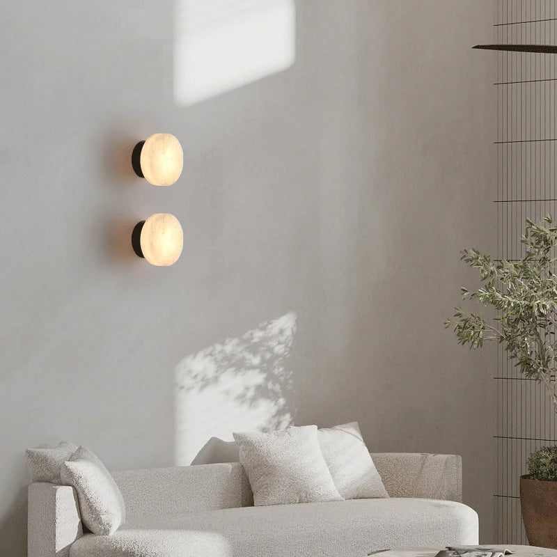 Black LED wall light pair with round marble-effect diffusers, soft warm glow