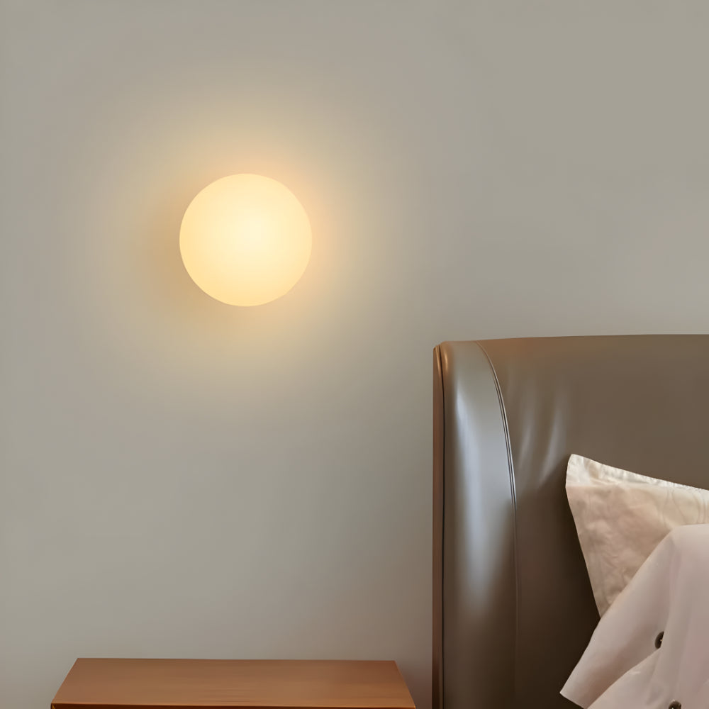Round warm white glass wall light with glowing globe
