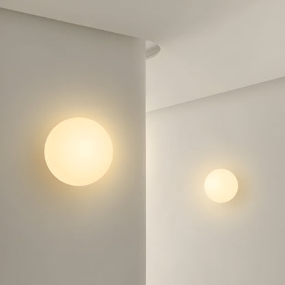 Round glass wall light with warm glowing globe