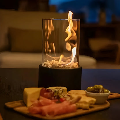 Tabletop bioethanol fireplace with clear glass fire bowl and black metal base, close flame view