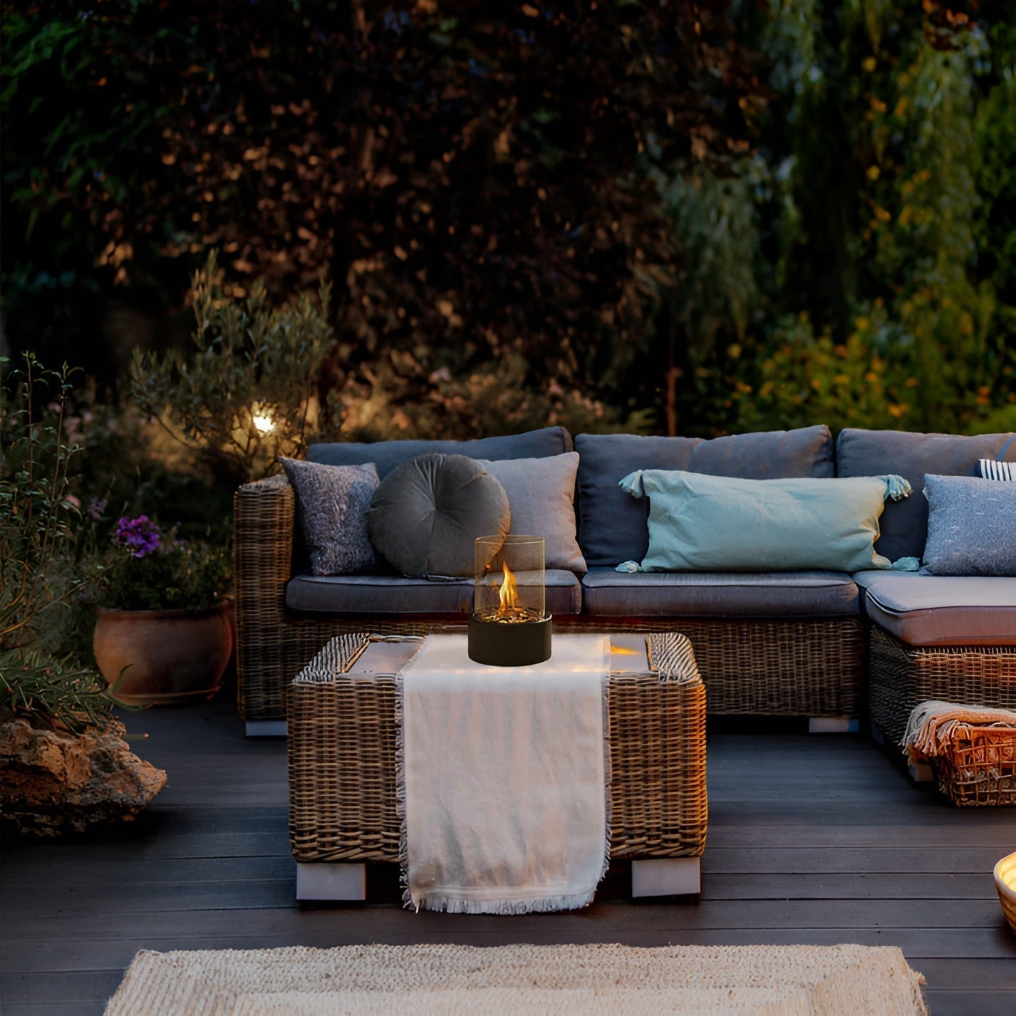 Tabletop bioethanol fireplace with clear glass fire bowl and black metal base, flames on terrace