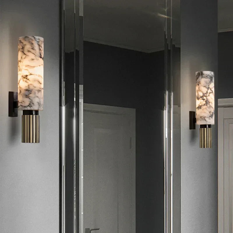 Wall-mounted marble-effect cylinder lights with black mounts and gold ribbed metal housings