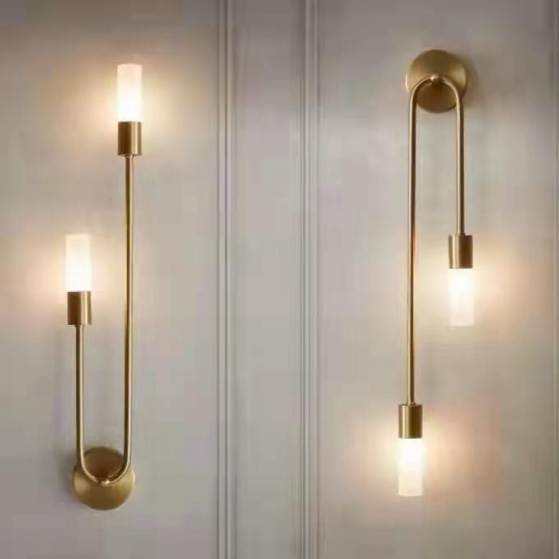 Gold LED wall sconces with curved backplates and warm white cylinder shade bulbs