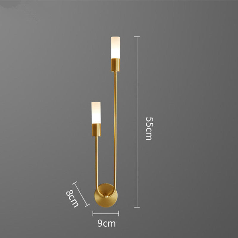Gold LED wall sconce with curved base and two warm white cylinder shades, slim frame